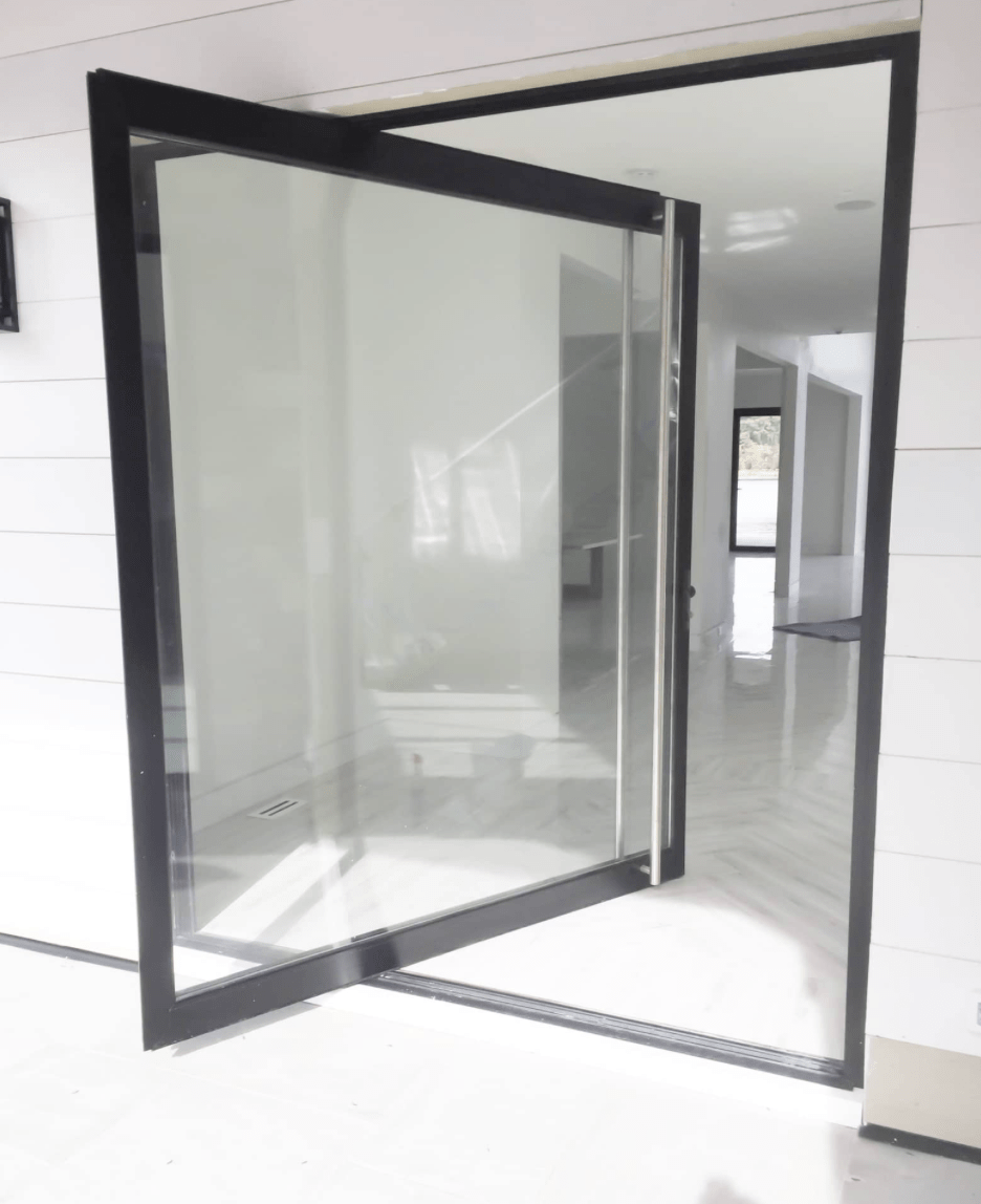 ActivWall(pivot) Glass door with a black frame partially open, leading to a hallway with white walls and glossy floor tiles.